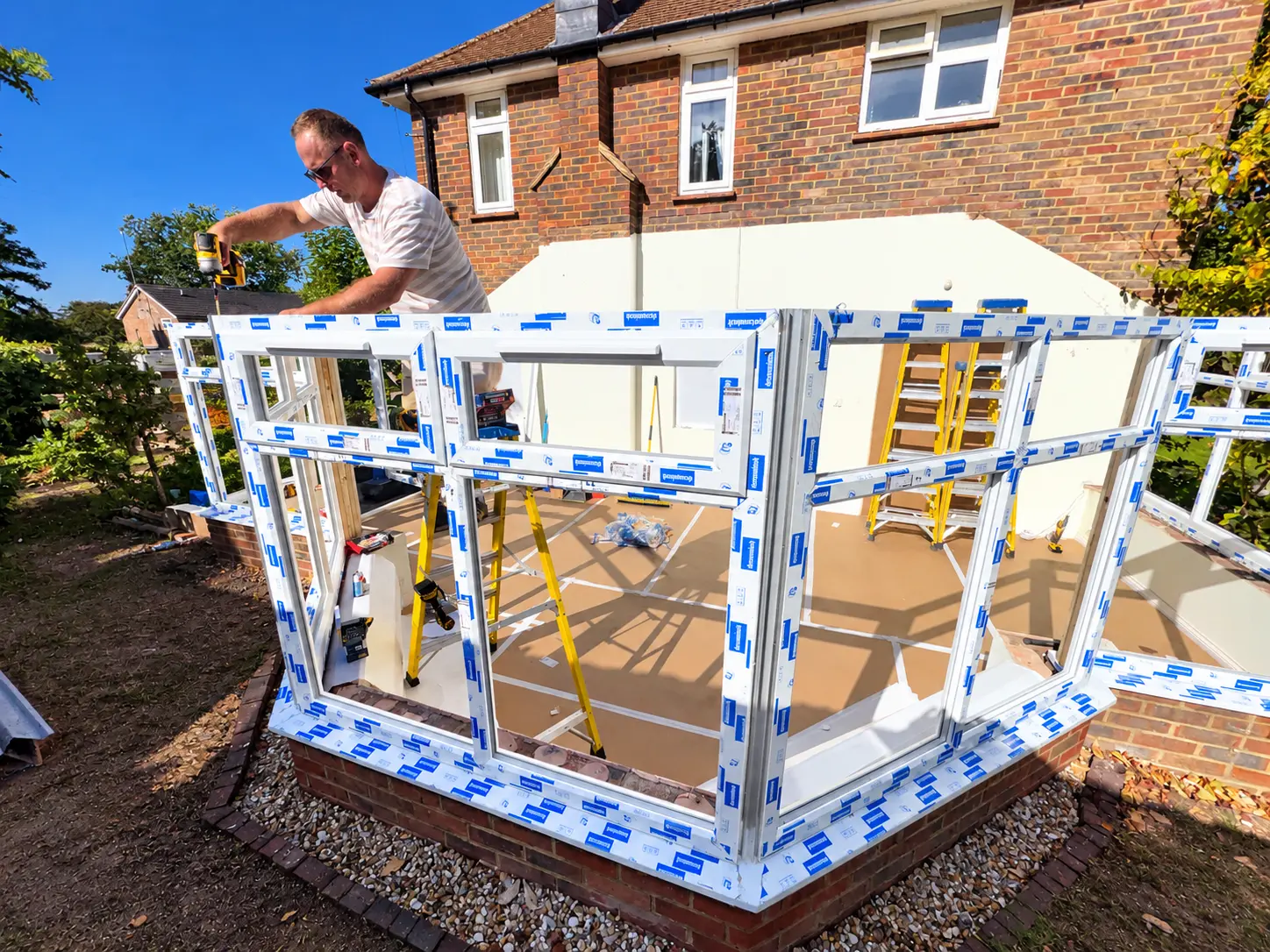 New wall frames New white uPVC conservatory wall frames being installed by 2Hot2Cold